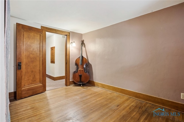 spare room featuring baseboards and light wood-style floors