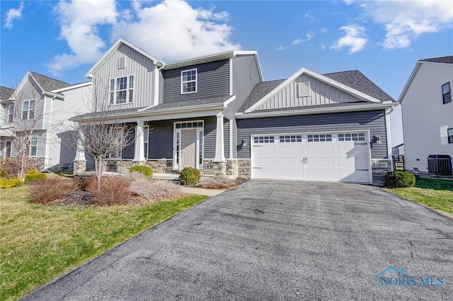 100 Bentley Dr, Perrysburg, OH 43551 - craftsman inspired home with stone siding, cooling unit, board and batten siding, aphalt driveway, and a garage