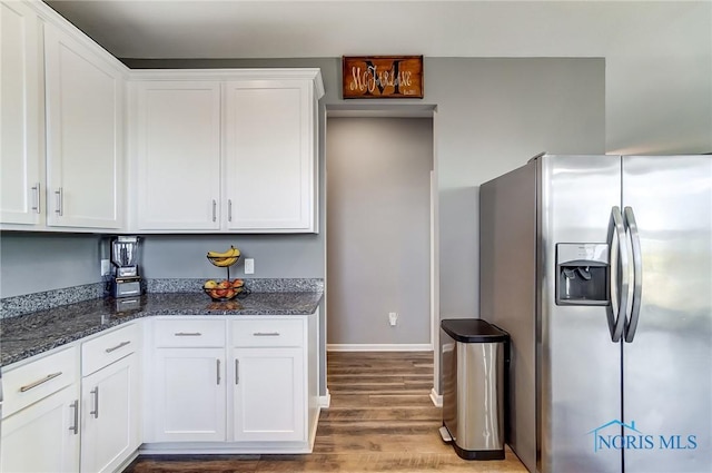 100 Bentley Dr, Perrysburg, OH 43551 - kitchen with white cabinetry, stainless steel fridge with ice dispenser, baseboards, dark stone counters, and wood finished floors