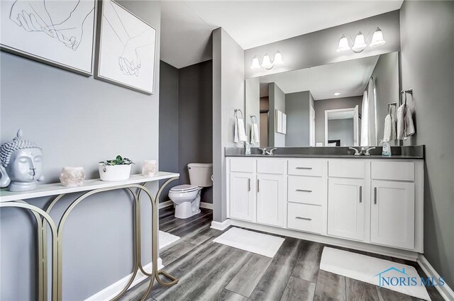 100 Bentley Dr, Perrysburg, OH 43551 - full bath with baseboards, double vanity, toilet, and wood finished floors