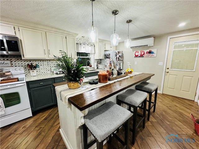 kitchen featuring decorative backsplash, a wall unit AC, dark wood-style floors, and white appliances