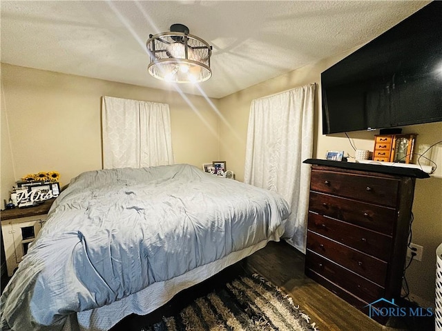 bedroom featuring a textured ceiling and wood finished floors