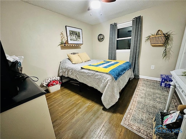 bedroom with baseboards, a textured ceiling, wood finished floors, and a ceiling fan