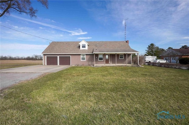 16325 Road 25P, Ottoville, OH 45844 - ranch-style home featuring concrete driveway, a porch, an attached garage, and a front lawn
