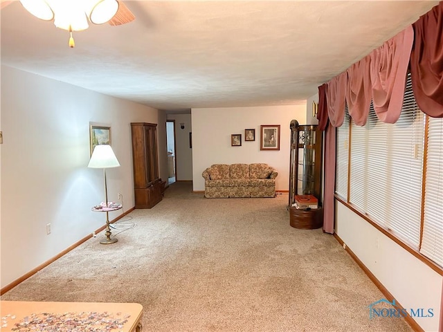 living area featuring baseboards and carpet flooring