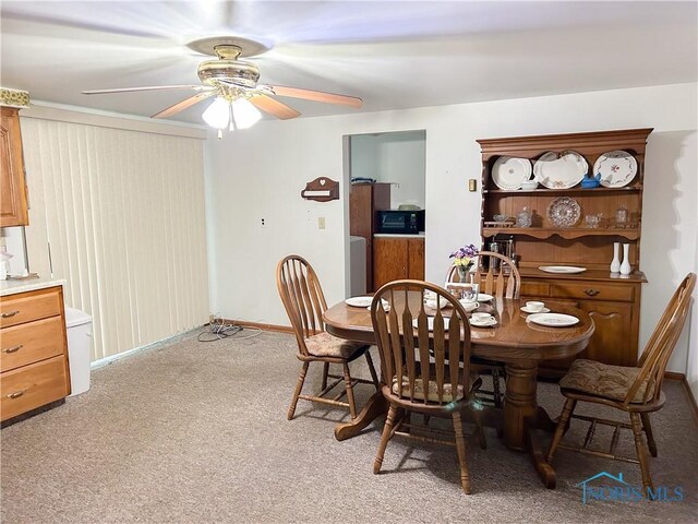 dining space featuring carpet floors, a ceiling fan, and baseboards