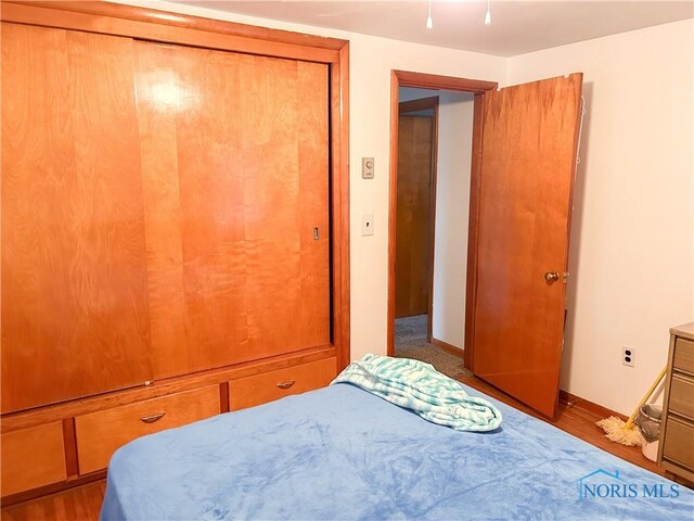 bedroom with wood finished floors and baseboards