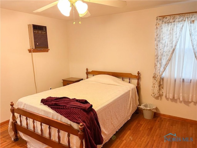 bedroom featuring baseboards, wood finished floors, and ceiling fan