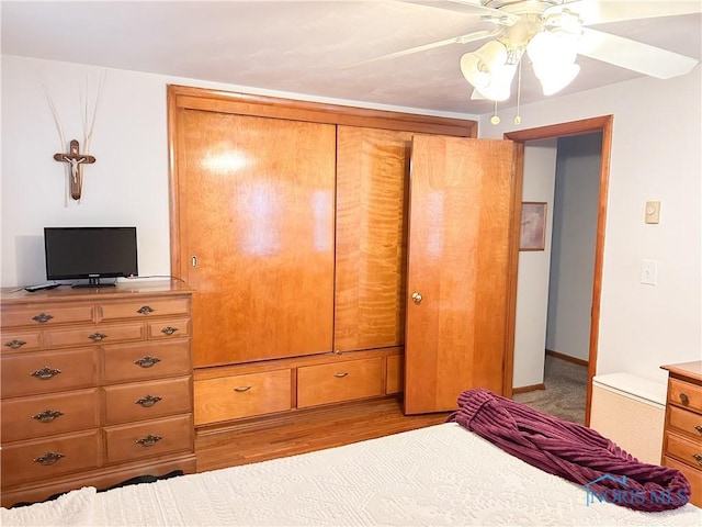 bedroom with light wood-style floors, baseboards, and ceiling fan