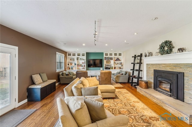 3114 Gleneagle Dr, Findlay, OH 45840 - living area featuring track lighting, a fireplace, light wood-style floors, built in features, and baseboards