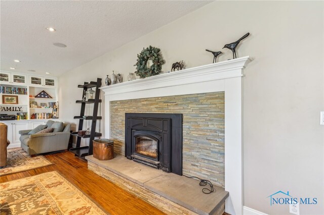 3114 Gleneagle Dr, Findlay, OH 45840 - details with a stone fireplace, recessed lighting, a textured ceiling, and wood finished floors