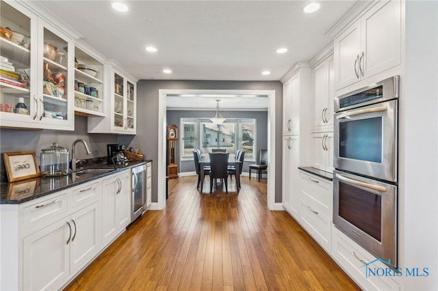 3114 Gleneagle Dr, Findlay, OH 45840 - kitchen featuring a sink, baseboards, double oven, and white cabinetry
