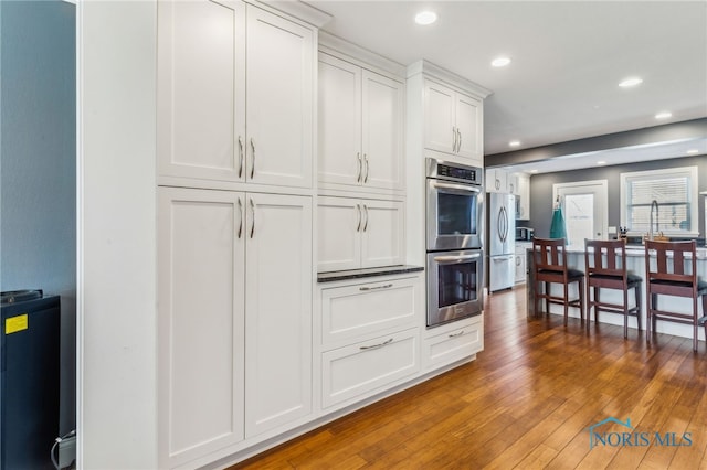 3114 Gleneagle Dr, Findlay, OH 45840 - kitchen featuring recessed lighting, white cabinetry, appliances with stainless steel finishes, and hardwood / wood-style flooring