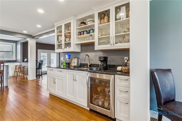 3114 Gleneagle Dr, Findlay, OH 45840 - bar featuring wine cooler, light wood-style floors, ornate columns, recessed lighting, and a sink