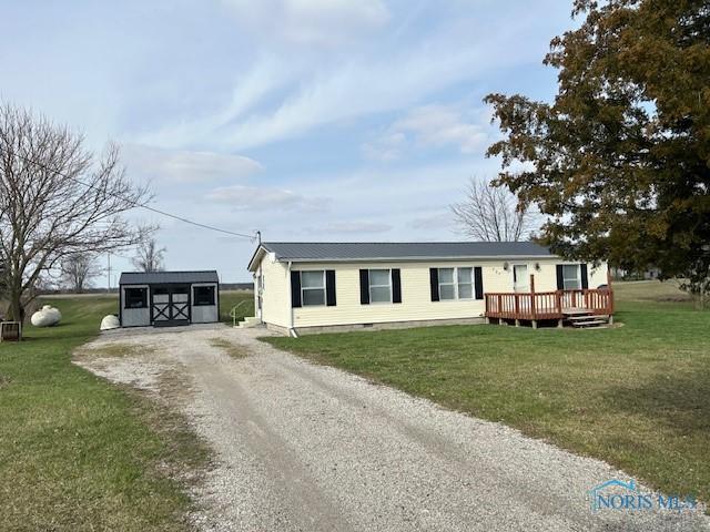 manufactured / mobile home featuring crawl space, a deck, a front lawn, driveway, and an outdoor structure
