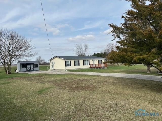 view of front facade featuring an outbuilding and a front lawn