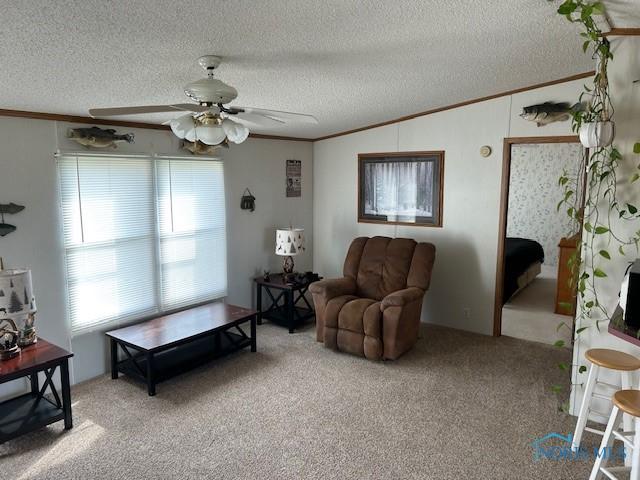 living area with ornamental molding, vaulted ceiling, ceiling fan, and light carpet
