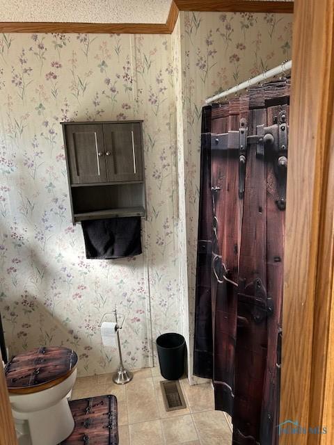 bathroom with wallpapered walls, visible vents, toilet, and tile patterned flooring