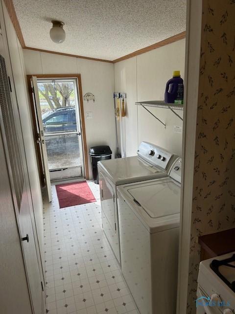 laundry area featuring tile patterned floors, washing machine and clothes dryer, laundry area, and a textured ceiling