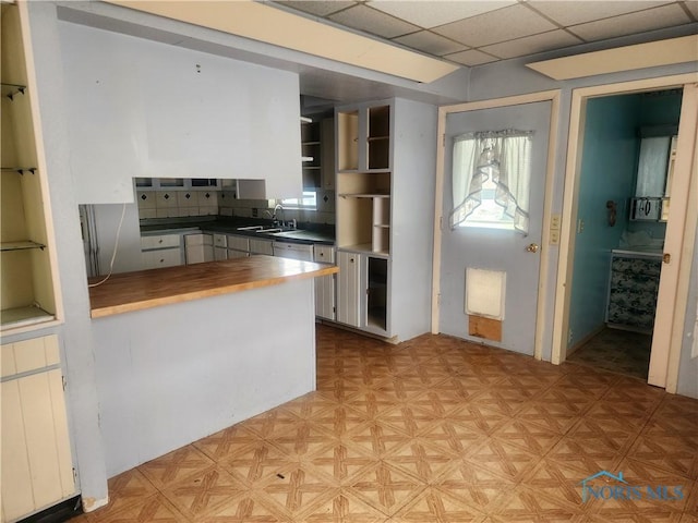 825 Park St, Findlay, OH 45840 - kitchen featuring a drop ceiling, wooden counters, a sink, a peninsula, and light floors