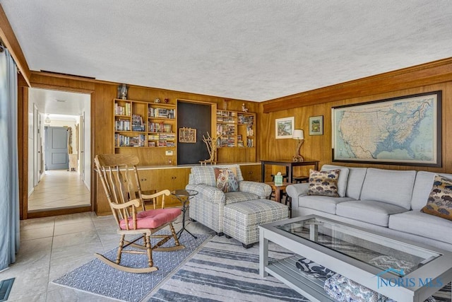living area featuring visible vents, wood walls, and a textured ceiling
