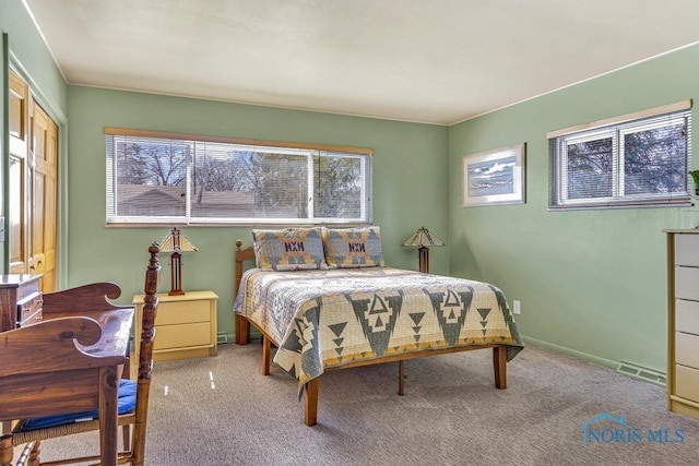 carpeted bedroom featuring baseboards, visible vents, and multiple windows
