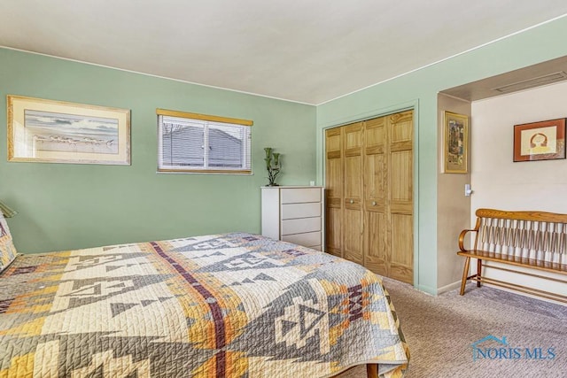 carpeted bedroom featuring baseboards, a closet, and visible vents