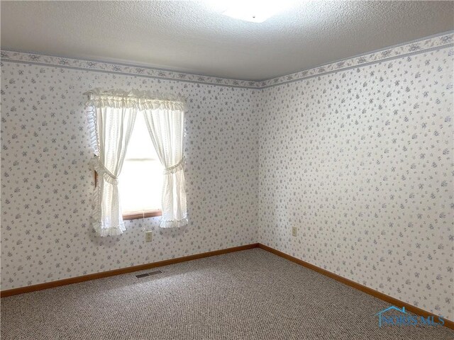 12783 Rd 82 Unit 1, Paulding, OH 45879 - carpeted spare room featuring visible vents, wallpapered walls, and a textured ceiling