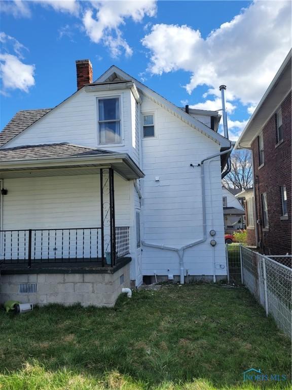 621 Nevada St, Toledo, OH 43605 - view of property exterior with a shingled roof, fence, a chimney, and a yard