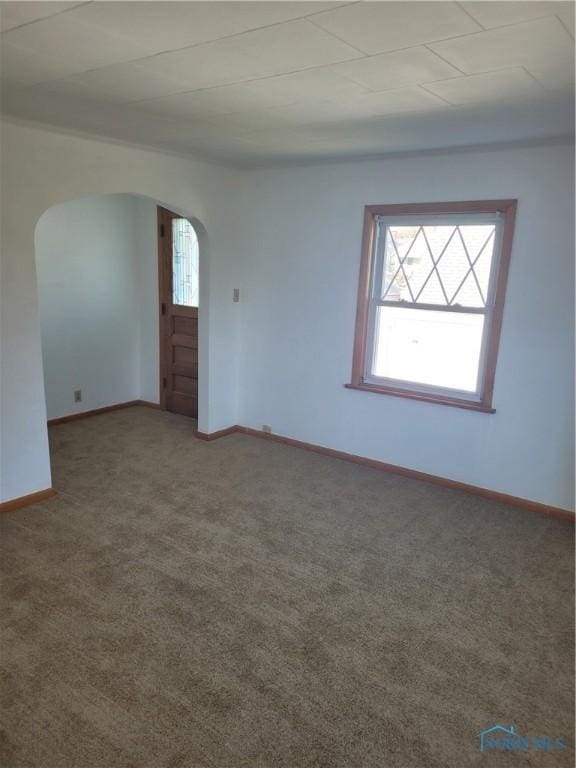 621 Nevada St, Toledo, OH 43605 - carpeted empty room featuring arched walkways, baseboards, and plenty of natural light
