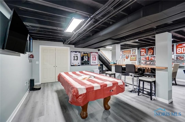 playroom with a bar, baseboards, pool table, and wood finished floors