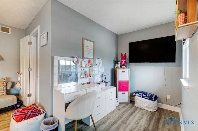 office space with light wood-style flooring, baseboards, and visible vents