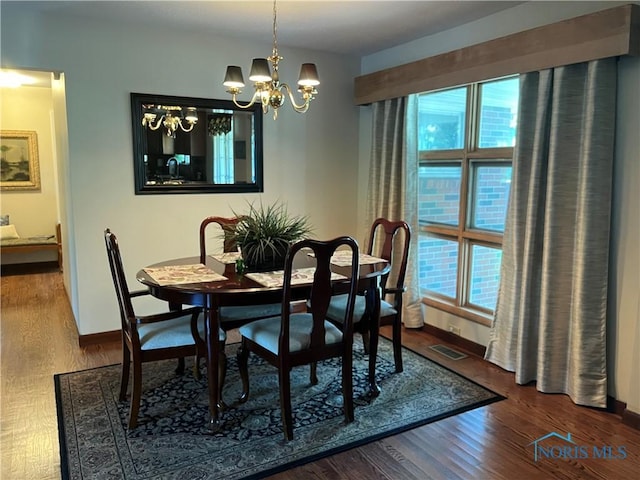 dining room featuring an inviting chandelier, wood finished floors, baseboards, and visible vents