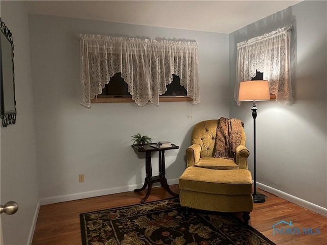 living area featuring baseboards and wood finished floors
