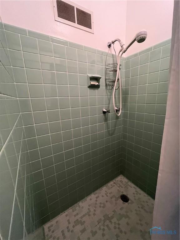 full bathroom featuring visible vents and a tile shower