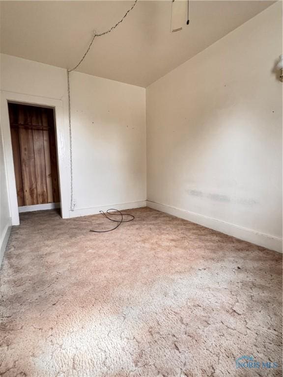 carpeted spare room featuring baseboards