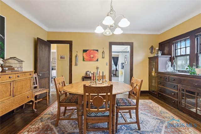 dining area with a chandelier and dark wood-style flooring