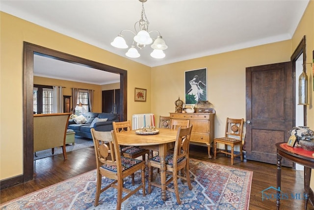 dining room with a chandelier, dark wood-style flooring, and radiator