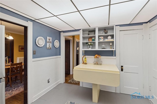bathroom with wainscoting and radiator