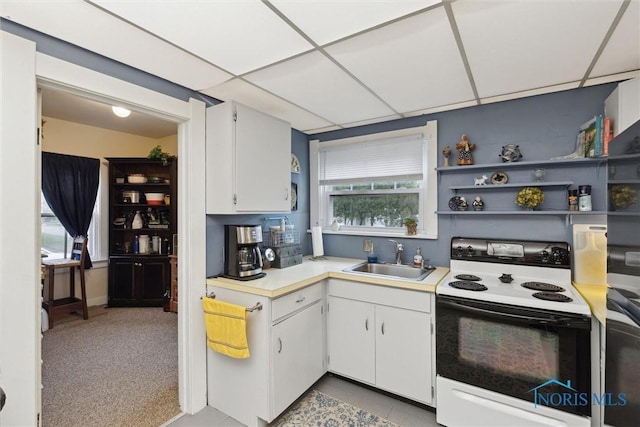 kitchen featuring white cabinets, light countertops, a sink, and electric range oven