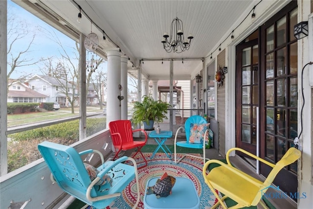 sunroom / solarium with a notable chandelier