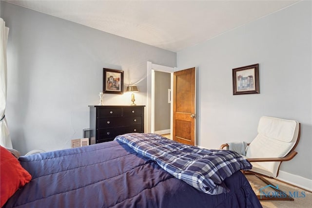 bedroom featuring baseboards and wood finished floors