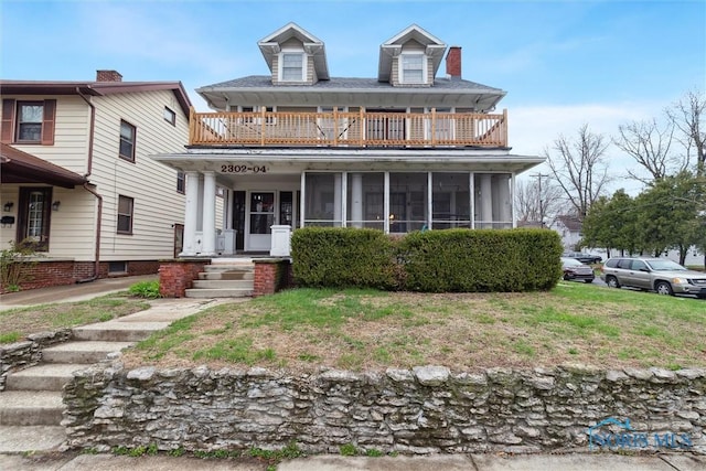 view of front of house with a sunroom and a balcony