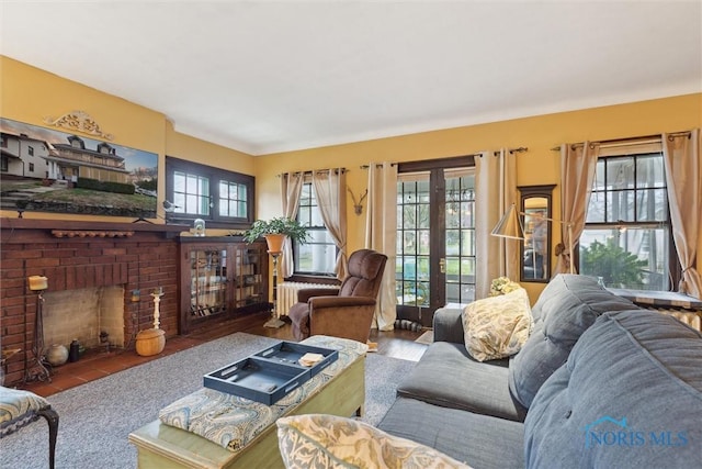 living room with french doors, radiator heating unit, and a fireplace