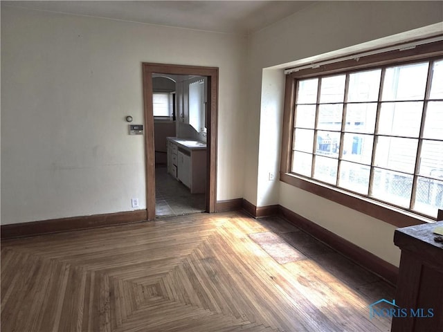 empty room with a sink and baseboards