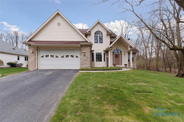 2016 Austin Bluffs Ct, Toledo, OH 43615 - traditional home with a garage, a front lawn, brick siding, a chimney, and driveway