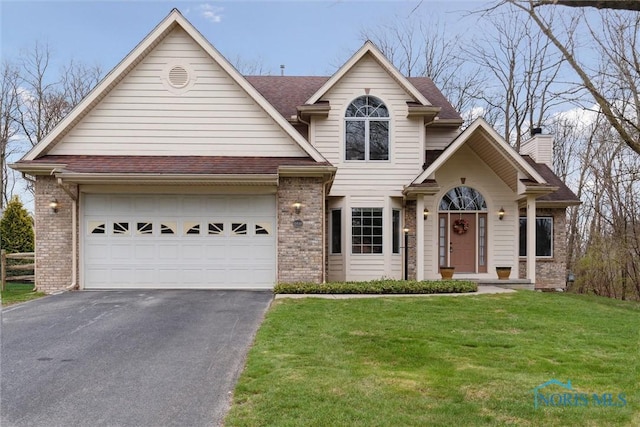2016 Austin Bluffs Ct, Toledo, OH 43615 - view of front of property with a front yard, brick siding, driveway, and a chimney