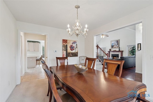 2016 Austin Bluffs Ct, Toledo, OH 43615 - dining area featuring ceiling fan with notable chandelier, light carpet, baseboards, and a lit fireplace