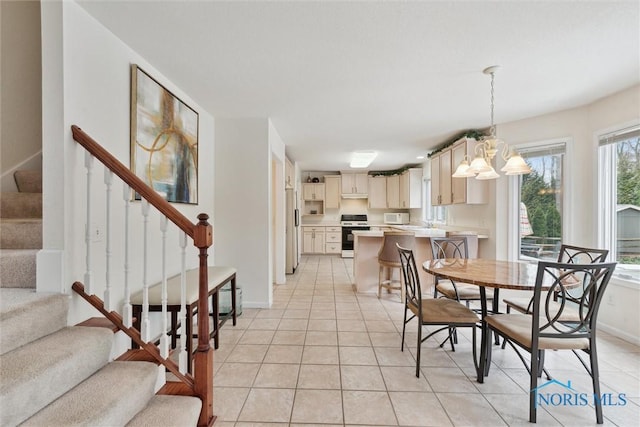 2016 Austin Bluffs Ct, Toledo, OH 43615 - dining space featuring stairway, light tile patterned floors, a notable chandelier, and baseboards