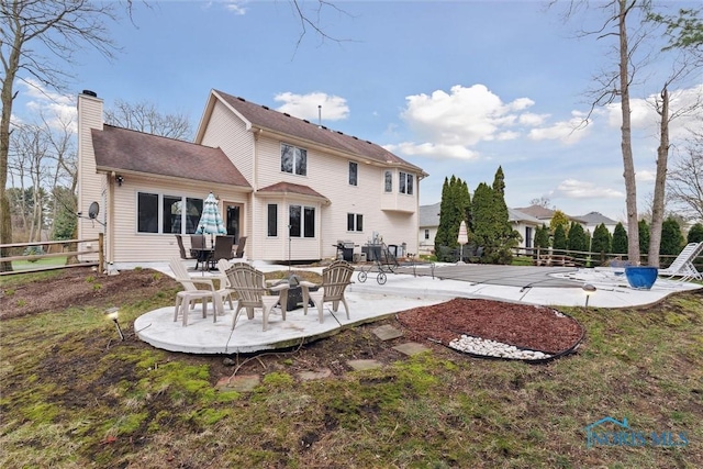 2016 Austin Bluffs Ct, Toledo, OH 43615 - back of property with a patio area, fence, and a chimney